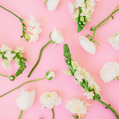 Floral pattern made of white ranunculus, snapdragon and tulip on pink background. Flat lay, top view. Background of flower