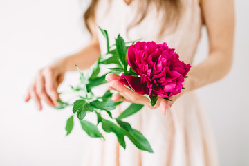 Woman holding bouquet of peonies in hands.