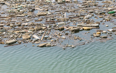 Plastic bottles and other trash floating in water