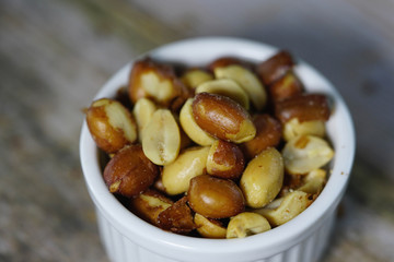 peanuts or beer nuts in a white bowl on the table