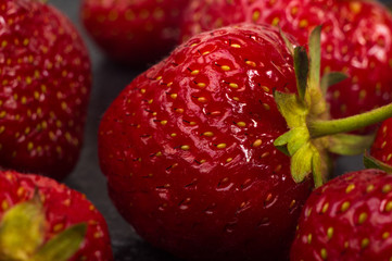 fresh ripe strawberries on black ceramic plate