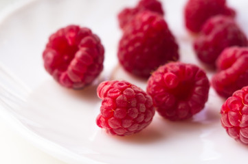 raspberries on a white saucer close up