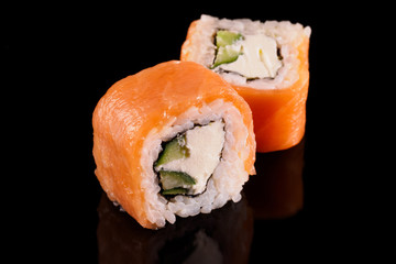 traditional fresh japanese sushi rolls on a black background