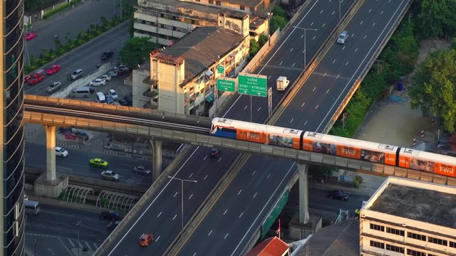 Sathorn road and intersection in transportation concept, BTS skytrain at sunset, Bangkok, Thailand
