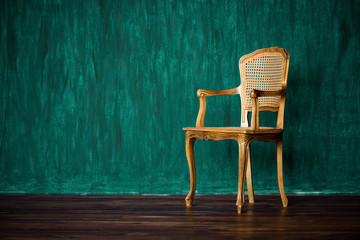 old chair on a green wall background.