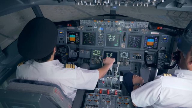 Two pilots get ready for a flight in a simulator. 4K.