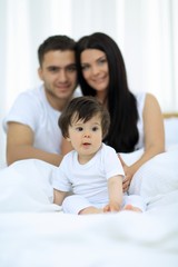 Fototapeta premium Happy couple and son sitting in bed