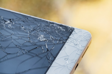 Broken display screen. Damaged smartphone glass. Closeup, yellow background, selective focus