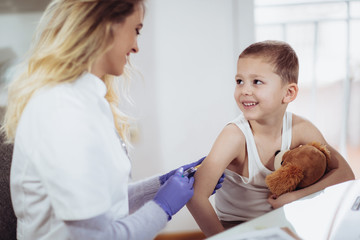 Doctor doing vaccine injection to a child, medicine, healthcare, pediatry and people concept