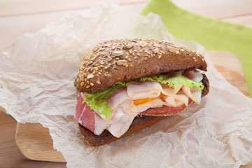 Tasty homemade sandwich with bacon on paper