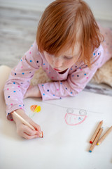 The girl draws in colored pencils