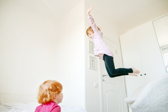 Children jump on the bed from the chair