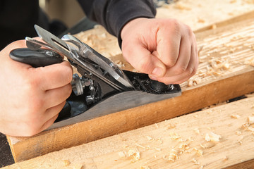 Carpenter working with smoothing plane, closeup