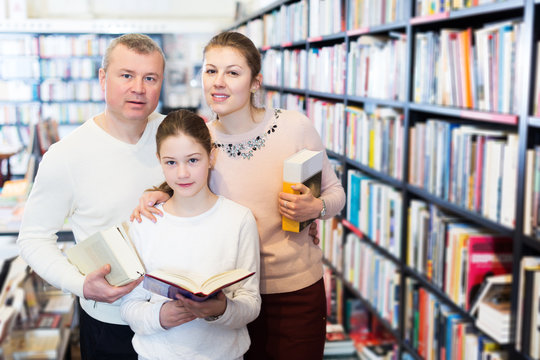 parents and little girl choosing books together