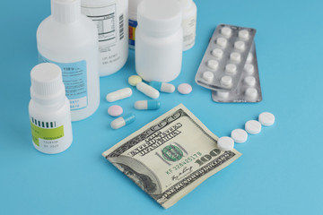 Pharmaceutical pills and bottle, hundred dollar bill. The concept of rise in price of medicines, pharmaceutical business.
