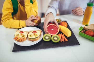 Mother making breakfast for her children in the morning and a snack for school