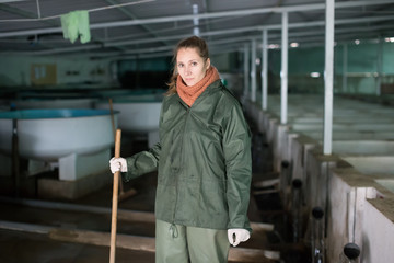 Fototapeta premium Woman watching fish in pool on farm