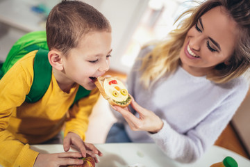 Mother making breakfast for her children in the morning and a snack for school