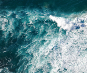 Fototapeta na wymiar Turquoise seawater with foamy waves, picture from above, abstract ocean background and texture