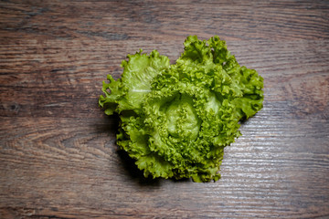 Fresh home-made green lettuce on a wooden background. Detached from the home garden.