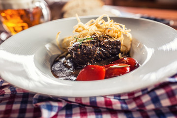 Confit beef steak with sauce fried onion bread draft beer and decoration in pub or restaurant
