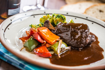 Confit rabbit leg with vegetable bread redvine in pub or restaurant