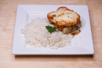 Boiled rice and a chicken cutlet on a white plate