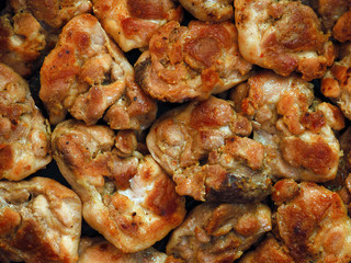 Pieces of roasted meat dark horizontal background. Top view. Grill, lunch and dinner, culinary or food background. Set of chicken meat barbecue roasted seasoned, close-up, macro