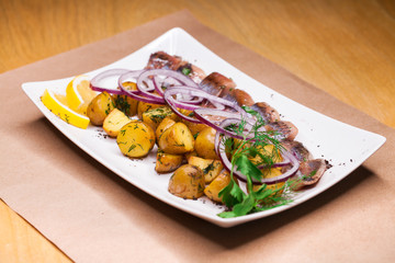 baked potatoes with onion rings and herring