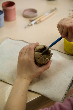 Child sculpts the product from raw clay