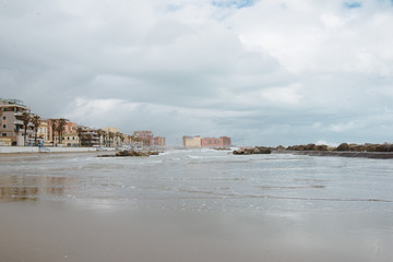 Fototapeta na wymiar row of buildings over coastline on cloudy day, Anzio, Italy