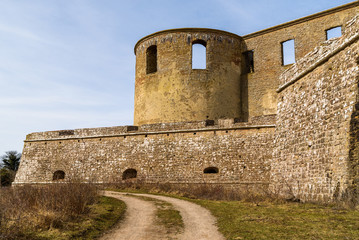 Historic castle ruin at Borgholm, Oland in Sweden. Gravel road outside one of the ruins towers and perimeter wall. A popular travel destination with historic values.