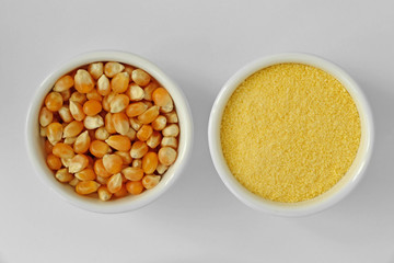 Dry corn kernels and corn flour in bowl on white background