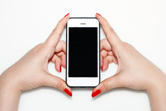 The girl is holding a white phone in her hand with red nails.
