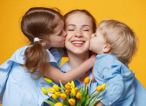 concept of mother's day. mom and children with flower on colored background.