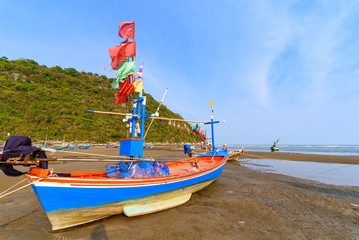 Fototapeta premium Fishing boats aground on the beach over sunny sky at Prachuap Khiri Khan, Thailand.