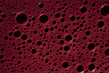 A liquid surface of dark bordeaux red bubbles. Clean above shot.
