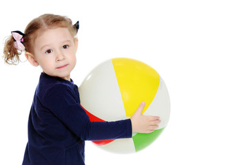 Little girl is playing with a ball