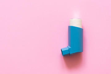 Aerosol for inhalation for the treatment of bronchial asthma on a pink pastel background.