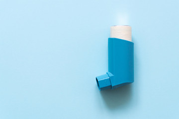 Aerosol for inhalation for the treatment of bronchial asthma on a blue pastel background.
