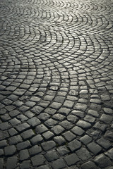 Full frame background of old-fashioned European cobbled plaza laid out in circular pattern in Naples, Italy