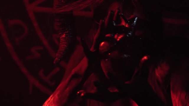 A girl in the guise of a witch rejoices just cut out a person's heart, body painting