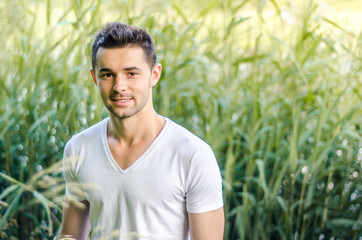 Naklejka na ściany i meble stylish brunette young healthy man smiling on the background of nature