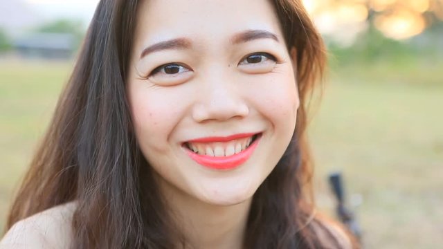 close up toothy smiling face of younger asian woman 