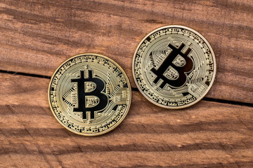 Golden bitcoin on wooden desk. Close up