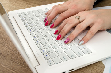 Hands of a woman on a laptop keyboard
