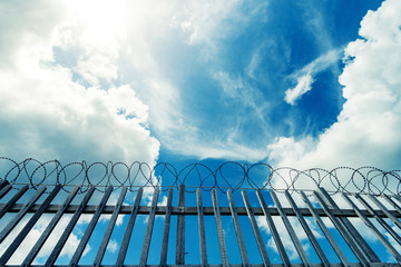Barbed wire fence surrounding a prison , military or other high security complex.