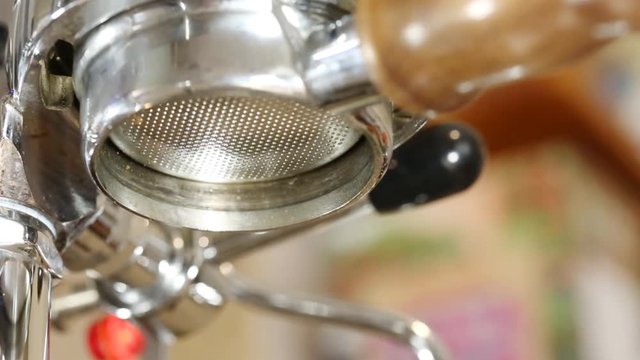 Brewing coffee at home using a nice stainless steeel coffee machine and bottomless portafilter. Barista making coffee at home.