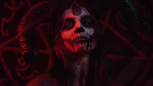 Satan with big horns looks indifferently in different directions