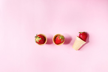 Fresh strawberries in waffle cups over pink pastel pin-up background. Copy space. Top view